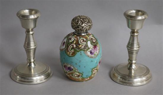 A pair of silver candlesticks and a silver topped porcelain scent bottle.